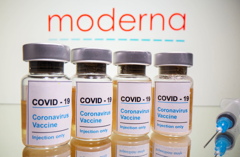 Vials with a sticker reading, "COVID-19 / Coronavirus vaccine / Injection only" and a medical syringe are seen in front of a displayed Moderna logo in this illustration taken October 31, 2020.  (photo credit: REUTERS)