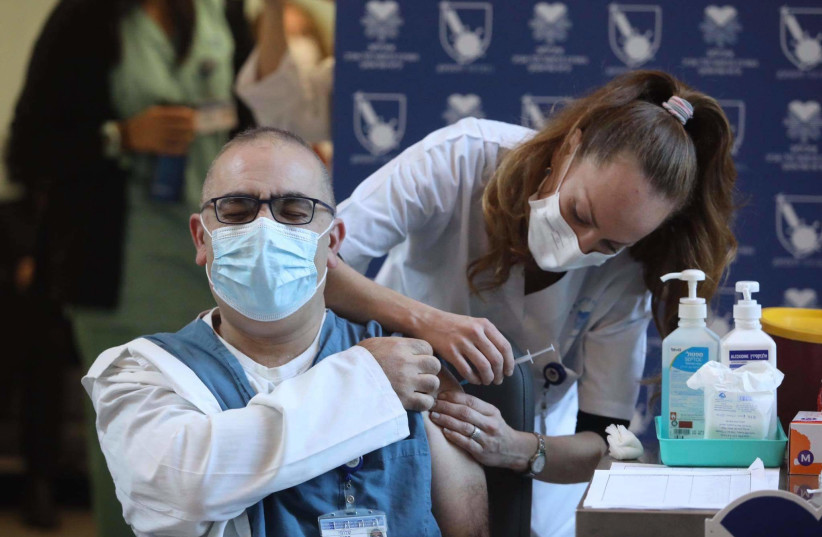 Medical staff receives vaccine in Ichilov Hospital, December 19, 2020 (photo credit: MARC ISRAEL SELLEM)