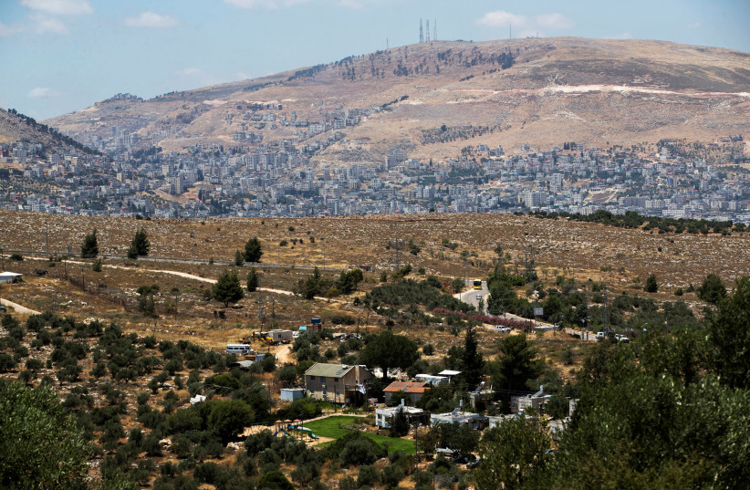 A general view picture shows a section of Itamar, a Jewish settlement, in the foreground as Nablus is seen in the background, in the West Bank June 15, 2020. (photo credit: RONEN ZVULUN/REUTERS)