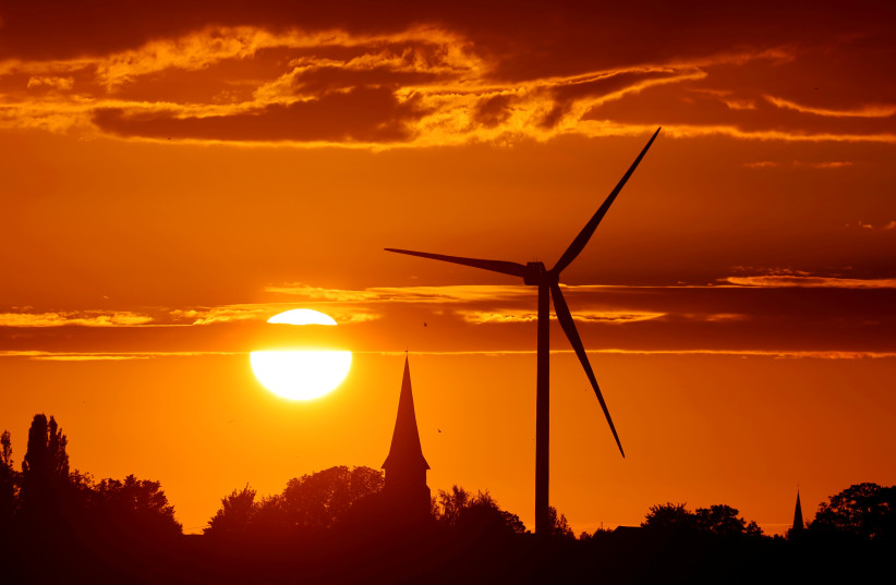 A power-generating windmill turbine is pictured during sunset at a renewable energy park in Ecoust-Saint-Mein, France (photo credit: PASCAL ROSSIGNOL/REUTERS)