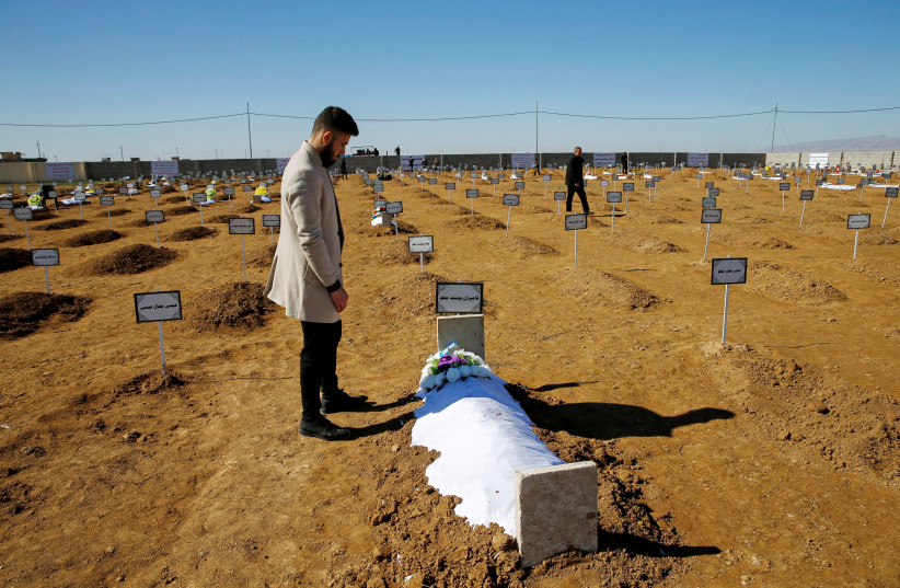 Thikran Kamiran Yousif, 22, visits his father's grave in Kojo, Iraq February 7, 2021.  (photo credit: REUTERS/THAIER AL-SUDANI)