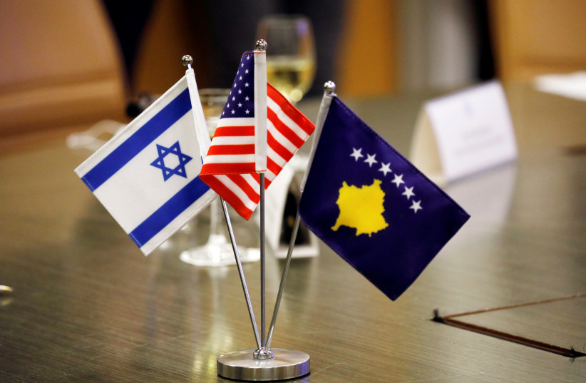 The flags of Israel, Kosovo and the US are seen on a desk during a virtual ceremony to sign an agreement establishing diplomatic relations between Israel and Kosovo in the Israeli foreign ministry in Jerusalem February 1, 2021 (photo credit: REUTERS/AMIR COHEN)
