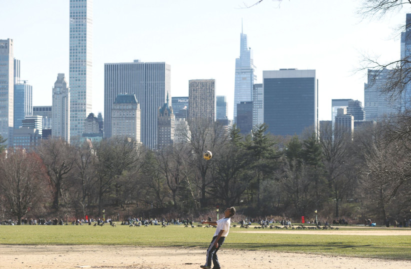 A MAN plays with a soccer ball in a field at Central Park on spring equinox, in the Manhattan borough of New York City, last week. (photo credit: CAITLIN OCHS/REUTERS)