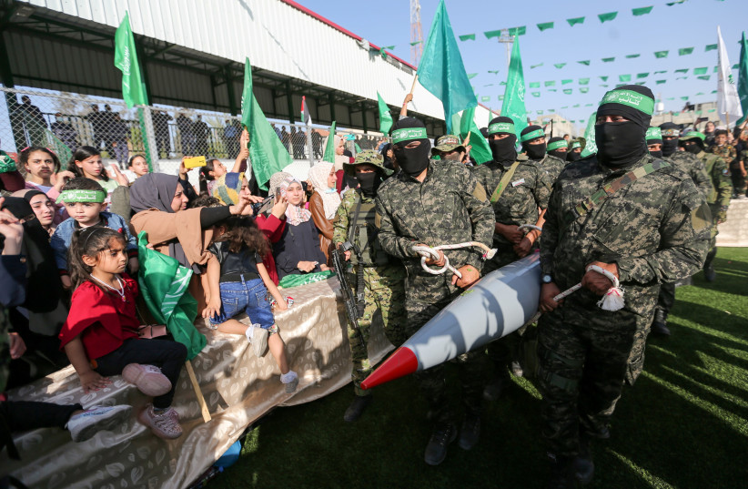 Palestinian Hamas militants carry a rocket as they parade during an anti-Israel rally in Rafah, in the southern Gaza Strip (photo credit: REUTERS/IBRAHEEM ABU MUSTAFA)