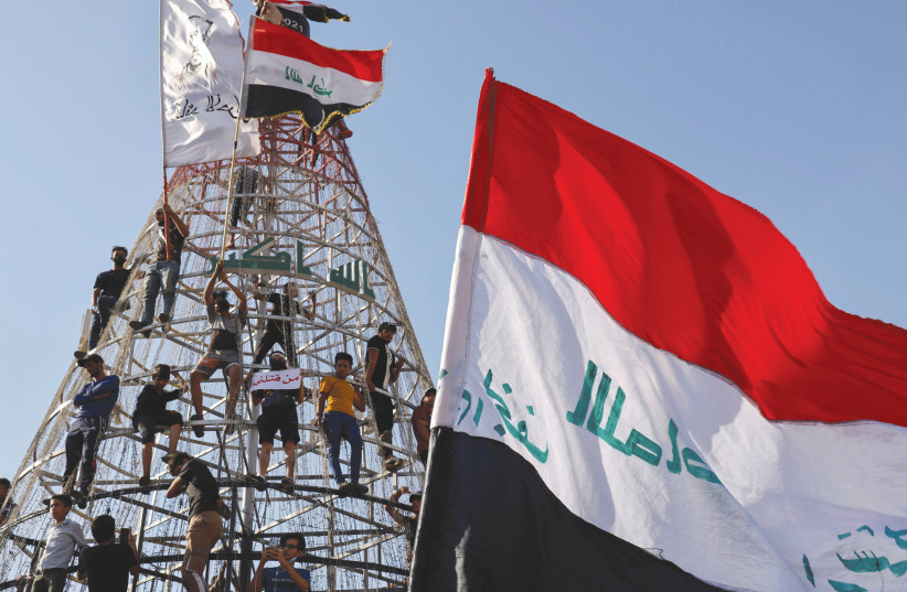 DEMONSTRATORS CLIMB a structure during an anti-government protest in Baghdad, last week. (photo credit: THAIER AL-SUDANI/REUTERS)