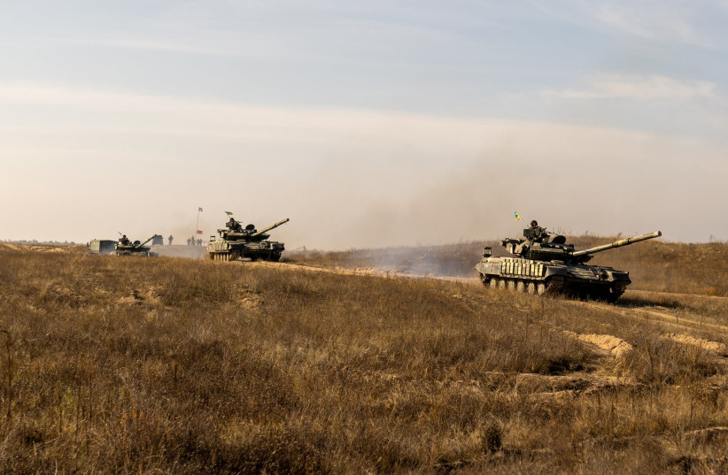 Tanks of the Ukrainian Armed Forces drive during military drills at a training ground near the border with Russian-annexed Crimea in Kherson region, Ukraine, in this handout picture released by the General Staff of the Armed Forces of Ukraine press service November 17, 2021. (photo credit: PRESS SERVICE OF GENERAL STAFF OF THE ARMED FORCES OF UKRAINE/HANDOUT VIA REUTERS)