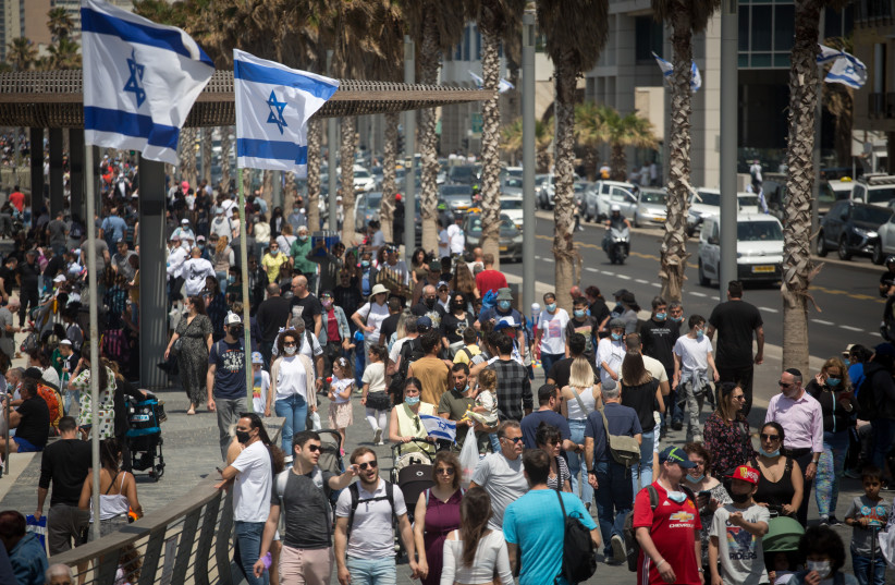  Thousands of Israelis walk on the beach boardwalk in Tel Aviv on Israel's 73d Independence Day, April 15, 2021. (photo credit: MIRIAM ALSTER/FLASH90)