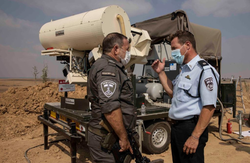 Police officers check a unit at a laser system aimed to intercept incendiary balloons, near the Gaza border. (photo credit: ISRAEL POLICE)
