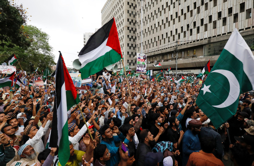  People carry flags as they chant slogans to express solidarity with Palestinian people and to protest against Israel, during a rally in Karachi, Pakistan May 21, 2021 (photo credit: Akhtar Soomro/Reuters)