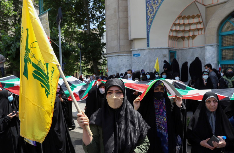  An Iranian woman holds a Hezbollah flag during a protest to express solidarity with the Palestinian people amid a flare-up of Israeli-Palestinian violence, in Tehran, Iran May 18, 2021.  (photo credit: MAJID ASGARIPOUR/WANA (WEST ASIA NEWS AGENCY) VIA REUTERS)
