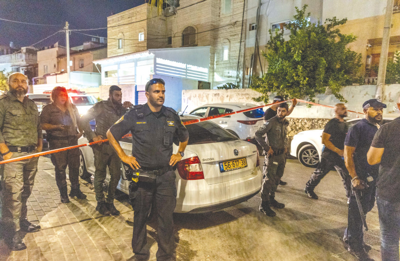  POLICE AND MEDICAL personnel at the scene of the murder of a woman in Lod, last week. (photo credit: YOSSI ALONI/FLASH90)