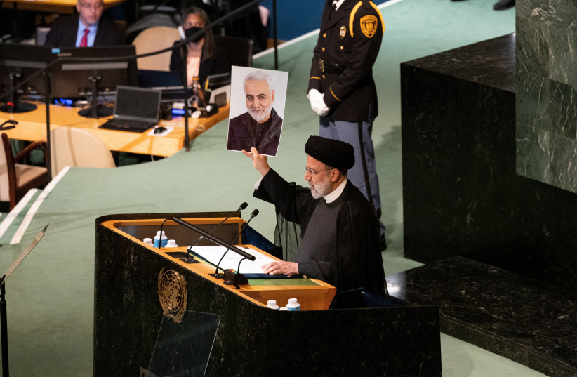  Iranian President Ebrahim Raisi holds ups photograph of General Qassem Soleimani during his speech at the 77th United Nations General Assembly at UN headquarters in New York City, New York, US, September 21, 2022. (photo credit: REUTERS/CAITLIN OCHS)
