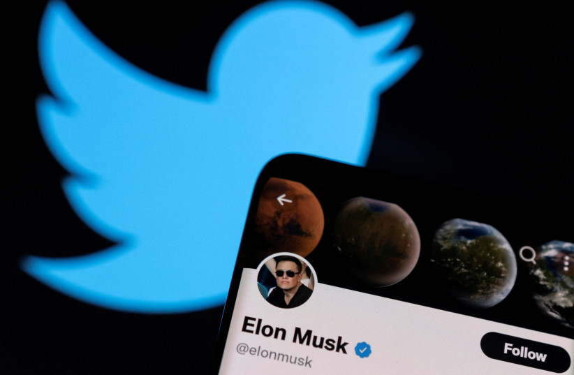  : Elon Musk's twitter account is seen on a smartphone in front of the Twitter logo in this photo illustration taken, April 15, 2022. (photo credit: REUTERS/DADO RUVIC/ILLUSTRATION)