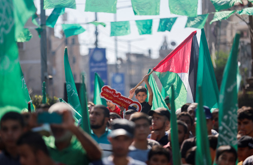  Palestinian Hamas supporters take part in an anti-Israel rally over tensions in Jerusalem's Al-Aqsa Mosque, in Khan Younis in the southern Gaza Strip on October 14, 2022 (photo credit: REUTERS/IBRAHEEM ABU MUSTAFA)