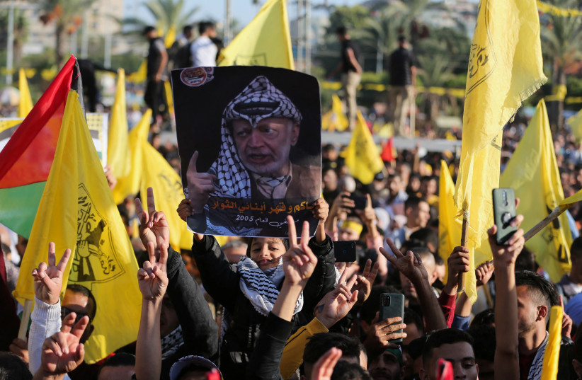  Palestinians take part in a Fatah rally marking the 18th anniversary of the death of late Palestinian leader Yasser Arafat, in Gaza City November 10, 2022. (photo credit: REUTERS/ IBRAHEEM ABU MUSTAFA)