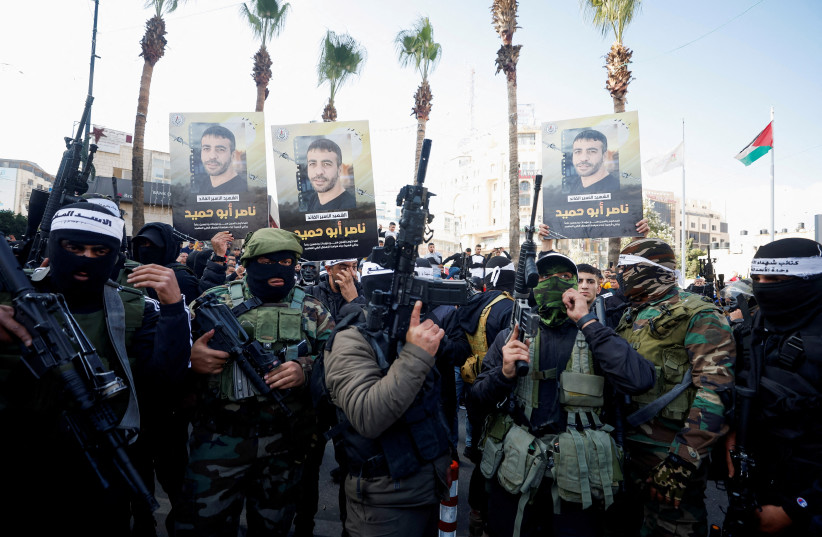   Palestinians including gunmen gather during a protest following the death of senior Palestinian militant Nasser Abu Hmaid who was jailed by Israel and died in an Israeli hospital where he had been moved to after his health deteriorated, in Ramallah in the West Bank December 20, 2022. (photo credit: REUTERS/MOHAMAD TOROKMAN)