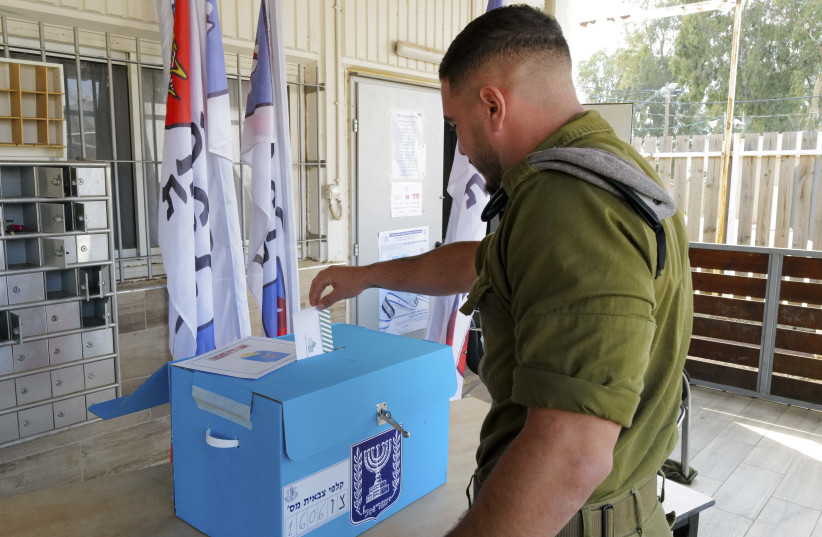  IDF soldiers cast their votes in a ballot box of the Golan Brigade 474 for Israel's general election at the Sa'ar military base in central Golan Heights on November 1, 2022.  (photo credit: MICHAEL GILADI/FLASH90)