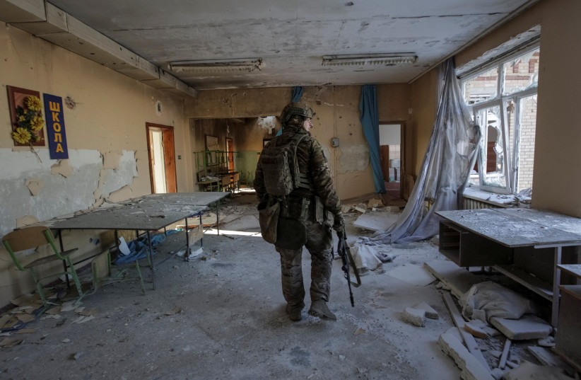  A Ukrainian serviceman is seen in a destroyed building of a school at a frontline, amid Russia's attack on Ukraine, in Donetsk region, Ukraine January 7, 2023. (photo credit: REUTERS/ANNA KUDRIAVTSEVA)