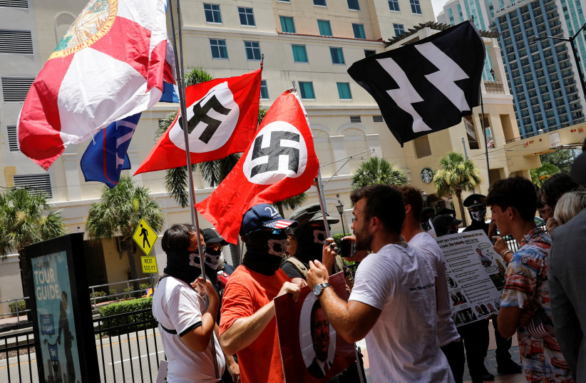 People waving Nazi swastika flags argue with conservatives during a protest outside the Tampa Convention Center, where Turning Point USA's (TPUSA) Student Action Summit (SAS) is being held, in Tampa, Florida, US July 23, 2022 (photo credit: REUTERS/MARCO BELLO)