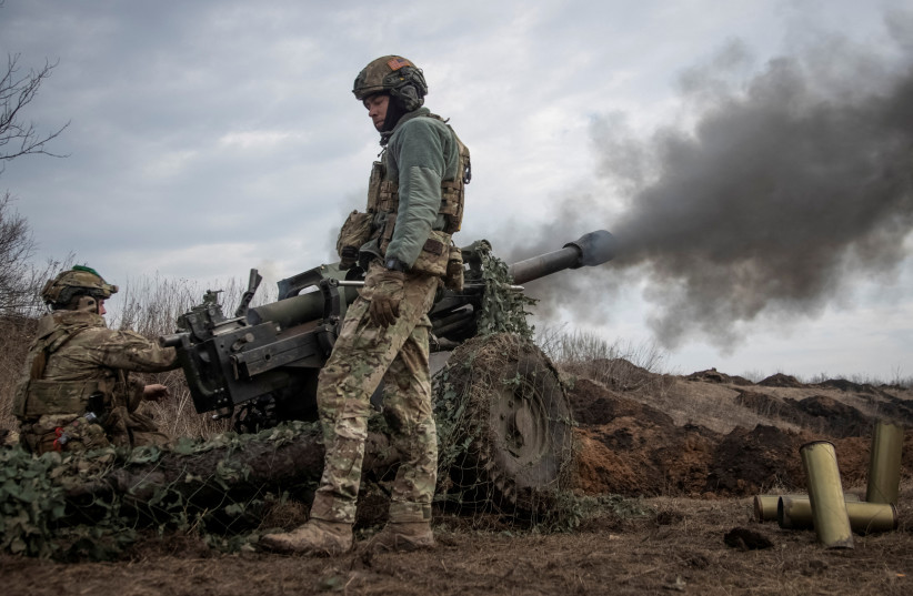 Ukrainian service members fire a howitzer M119 at a front line, amid Russia's attack on Ukraine, near the city of Bakhmut, Ukraine, March 10, 2023. (photo credit: REUTERS/OLEKSANDR RATUSHNIAK/FILE PHOTO)