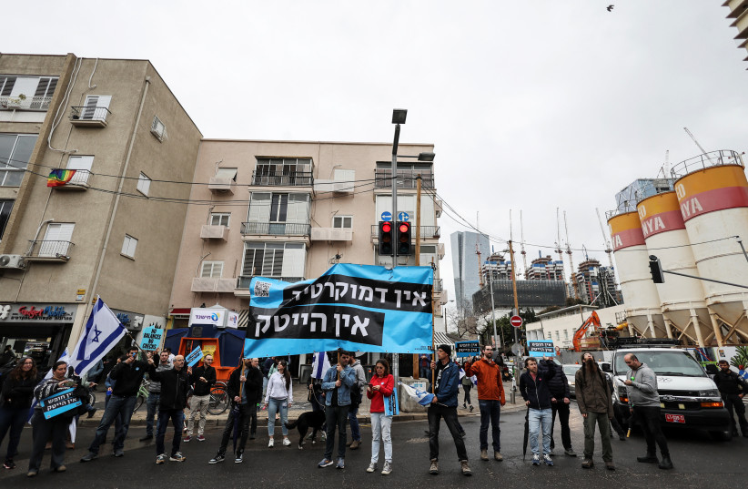  Demonstrators hold a banner during a protest by Israel's hi-tech sector, as Prime Minister Benjamin Netanyahu's nationalist coalition government presses on with its judicial overhaul, in Tel Aviv, March 14. 2023. The banner reads "Without democracy there is no hi-tech".  (photo credit: REUTERS/NIR ELIAS)