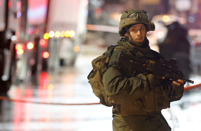  An Israeli troop stands guard, at the scene of a shooting, in Huwara, in the West Bank, March 19, 2023. (photo credit: MOHAMAD TOROKMAN/REUTERS)