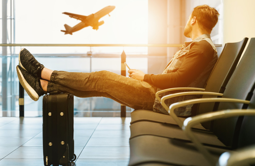  A man waits for a flight in the airport (illustrative) (photo credit: PEXELS)