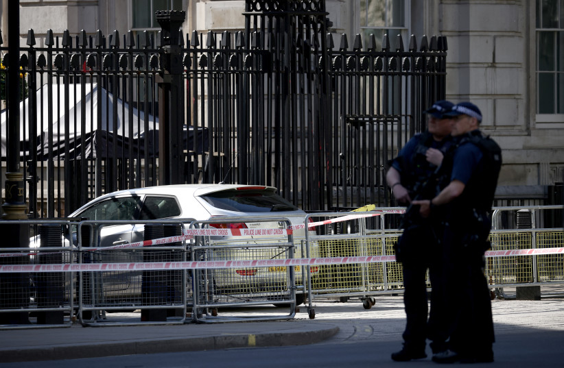 Police officers stand guard neat the site where a car crashed into the front gates of Downing Street in London, Britain, May 25, 2023. (photo credit: HENRY NICHOLLS/REUTERS)