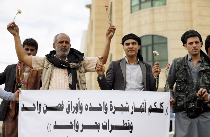 Members of the Baha'i faith demonstrate during a hearing in the case of a fellow Baha'i charged with seeking to establish a base for the community in Yemen, Sanaa April 3, 2016. "You all are the fruits of one tree, the leaves of one branch and the drops of one sea." (photo credit: KHALED ABDULLAH/REUTERS)
