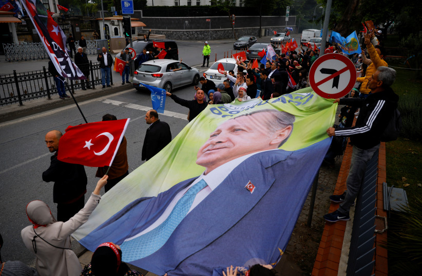 Supporters of Turkish President Tayyip Erdogan carry a banner with his image on the day of the second round of the presidential election in Istanbul, Turkey May 28, 2023. (photo credit: REUTERS/KEMAL ASLAN)