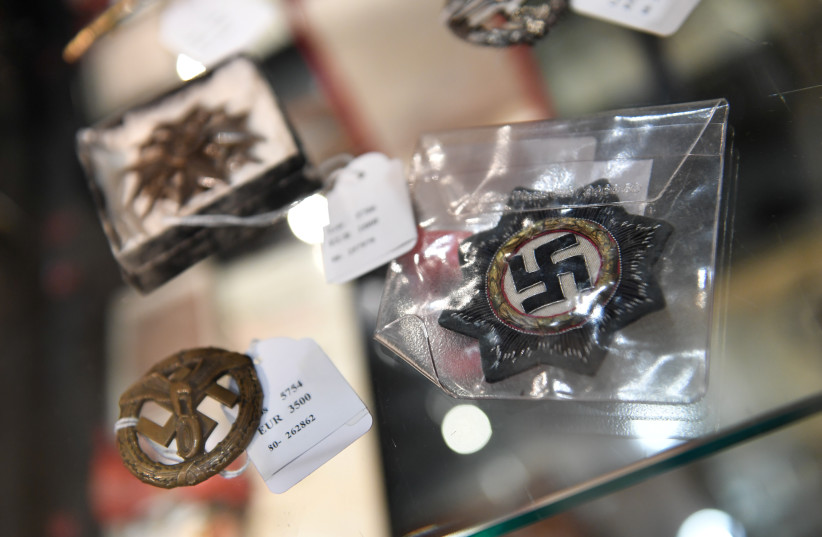 Exhibits from the Nazi era are seen in a cupboard at the auction house Hermann Historica in Munich, Germany, November 20, 2019. Several hundred Nazi objects were up for auction, amongst them Adolf Hitler's hat and one of Eva Braun's dresses. (photo credit: ANDREAS GEBERT/REUTERS)