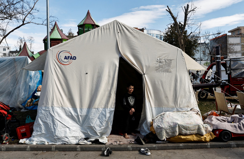  The son of a Syrian refugee Mohammed al-Kashif stands at the entrance of a tent, where Mohammed lives with his family on a public park ground, after his house collapsed due to the deadly earthquake, in Adiyaman, Turkey February 15, 2023. (photo credit: THAIER AL-SUDANI/REUTERS)