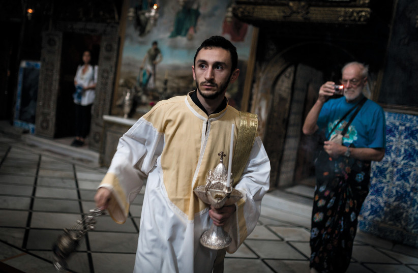  ACTS SUCH as spitting on Armenian priests in the Old City have become routine: A young clergyman takes part in Sunday mass. (photo credit: FLASH90)