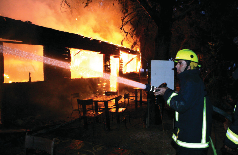  LONG HISTORY of bravery: Battling to extinguish a fire in a Kibbutz Nir Am restaurant, hit by a rocket fired from the Gaza Strip, 2007.  (photo credit: EDI ISRAEL/FLASH90)