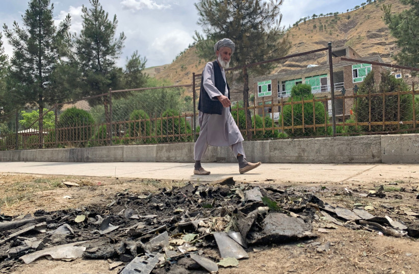  A man walks past the site of a suicide attack along the roadside in Faizabad district of Badakhshan province on June 6, 2023 (photo credit: OMER ABRAR/AFP via Getty Images)