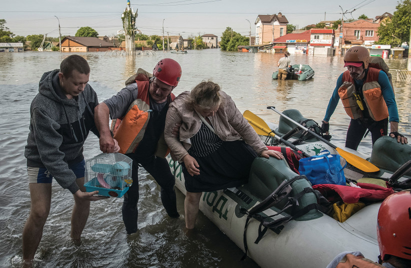  RESCUERS EVACUATE local residents from a flooded area after the Nova Kakhovka dam was breached in Kherson, amid Russia’s attack on Ukraine. (photo credit: Vladyslav Musiienko/Reuters)