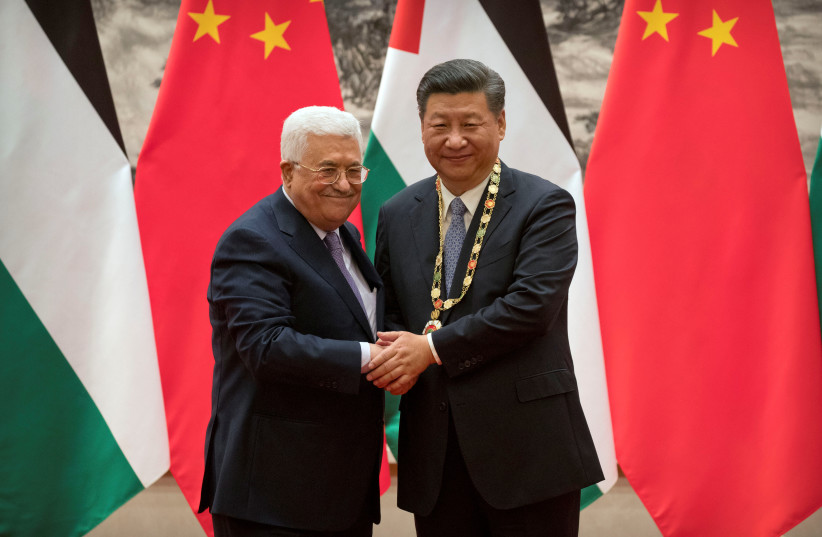  Palestinian President Mahmoud Abbas, left, shakes hands after presenting a medallion to Chinese President Xi Jinping, right, during a signing ceremony at the Great Hall of the People in Beijing, China, July 18, 2017. (photo credit: REUTERS/MARK SCHIEFELBEIN/POOL)