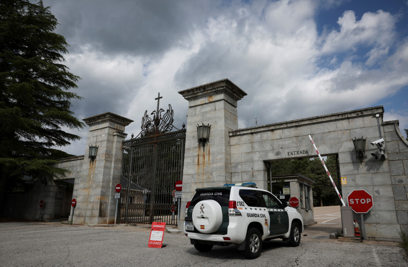  A police vehicle passes a sign informing visitors that the 'Valley of the Fallen' monument, now known as Valley of Cuelgamuros, is closed to the general public as forensic scientists begin work to remove the remains of 128 victims of the Spanish Civil War who are buried at the site, near Madrid, Sp (photo credit: REUTERS/VIOLETA SANTOS MOURA)
