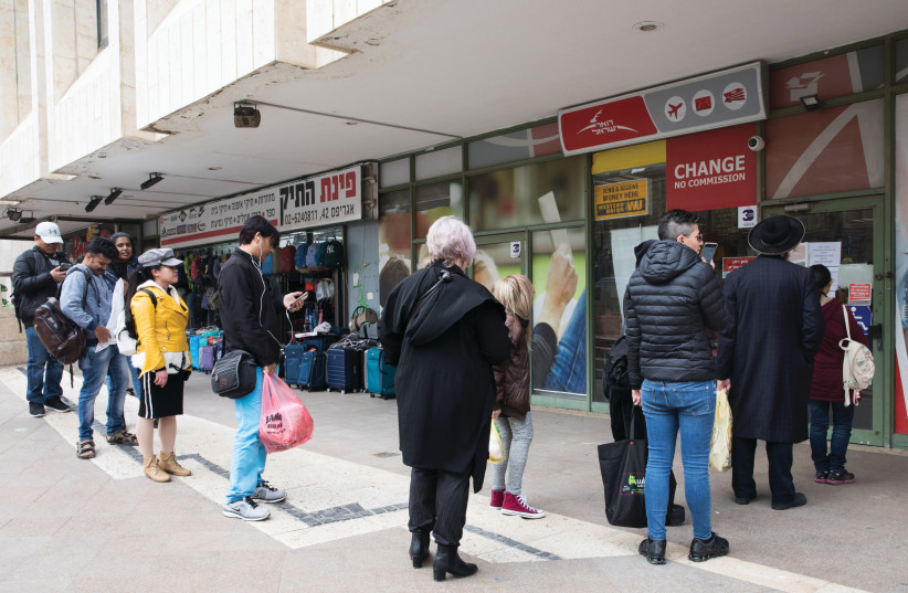  PEOPLE WAIT in a long line outside a post office in Jerusalem. (photo credit: NATI SHOHAT/FLASH90)