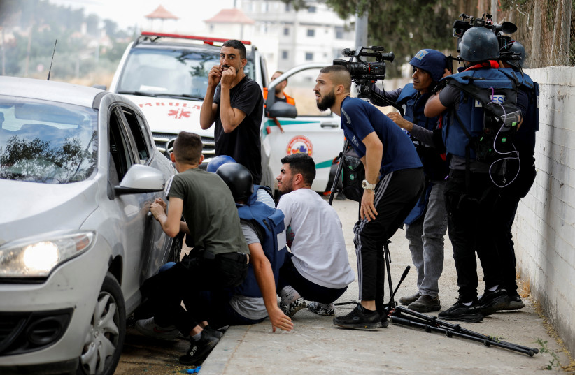  Palestinians and members of the media react during an Israeli raid in Jenin, in the Israeli-occupied West Bank June 19, 2023. (photo credit: REUTERS/RANEEN SAWAFTA)