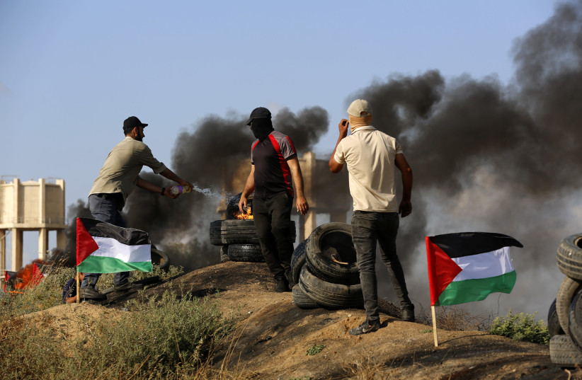 Palestinian demonstrators burn tires during a protest over tension in Jenin, at the Israel-Gaza border fence, east of Gaza City June 19, 2023. (photo credit: ATIA MOHAMMED/FLASH90)