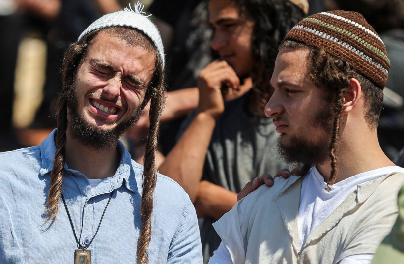  A man reacts, as friends and family mourn 17-year-old Israeli Nachman Shmuel Mordoff, who was killed in a Palestinian terrorist attack along with three other Israelis near the settlement of Eli, at his funeral in Shilo in the West Bank, on June 21, 2023. (photo credit: NIR ELIAS/REUTERS)