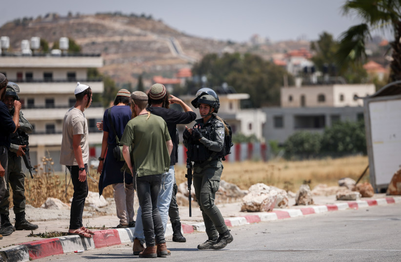  Israeli soldiers and settlers at the entrance to the West Bank village of  Turmus Aiya, June 21, 2023 (photo credit: YONATAN SINDEL/FLASH90)