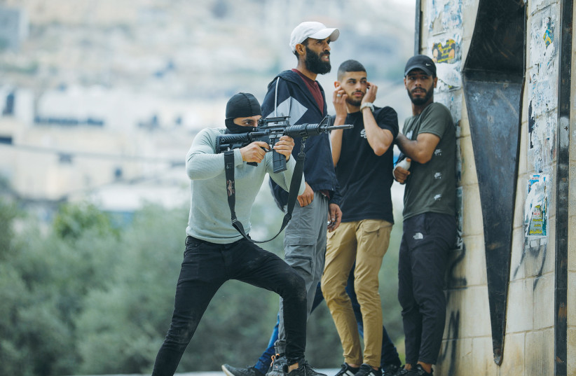  A PALESTINIAN gunman fires toward Israeli troops in Jenin this week.  (photo credit: RANEEN SAWAFTA/REUTERS)