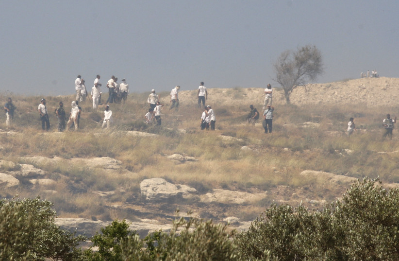  Israeli settlers stand on a hill next to the village of Orif near the West Bank City of Nablus May 26, 2012. (photo credit: REUTERS/ABED OMAR QUSINI)