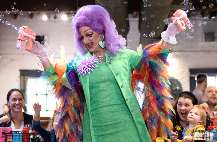  "Tara Hoot", a Drag Queen originally from Terre Haute, Indiana, uses bubble makers above audience members during a Drag Story Hour at Crazy Aunt Helen's restaurant in the Eastern Market neighborhood of Washington, U.S., April 29, 2023. (photo credit: REUTERS)