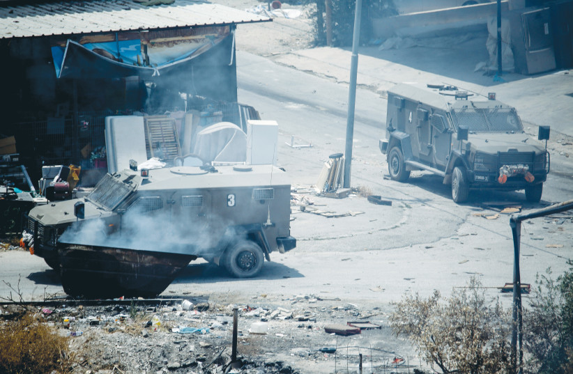  ISRAELI MILITARY vehicles are seen during clashes between security forces and Palestinians in Jenin. (photo credit: NASSER ISHTAYEH/FLASH90)