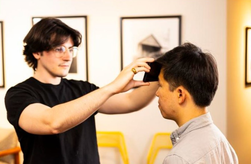 A team led by researchers at the University of Washington has created an app — FeverPhone — that transforms smartphones into thermometers without adding new hardware. To take someone’s temperature, the screen of a smartphone is held to a patient's forehead. (photo credit: Dennis Wise/University of Washington)