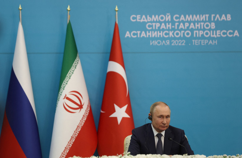  Russian President Vladimir Putin attends a news conference following the Astana Process summit in Tehran, Iran July 19, 2022. Russian, Iranian and Turkish flags hang behind him. (photo credit: MAJID ASGARIPOUR/WANA/REUTERS)