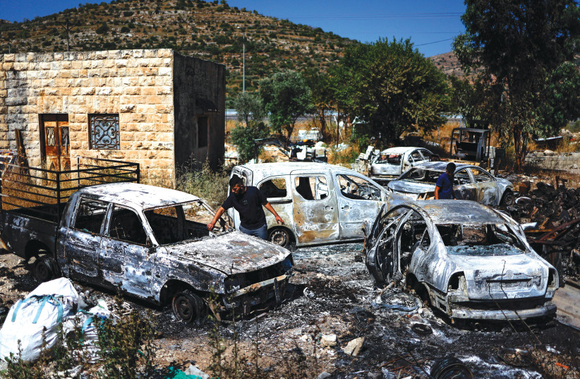  PALESTINIANS INSPECT gutted vehicles after settlers attacked near Ramallah last week (photo credit: AMMAR AWAD/REUTERS)